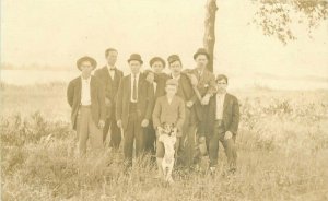 C-1910 Group Men wearing hats Stand up dog RPPC Photo Postcard 20-4008