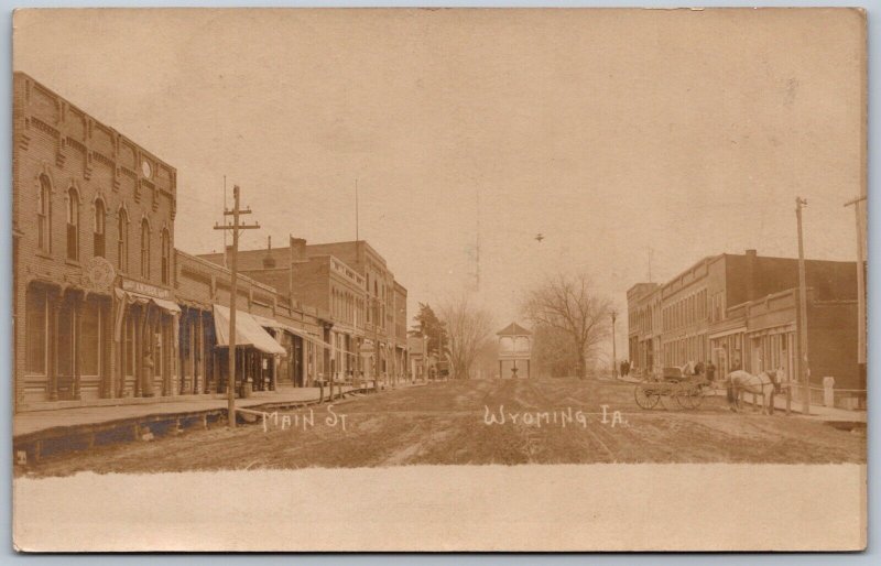 Postcard RPPC c1907 Wyoming Iowa Main Street Shops Signs Horse Buggy Printshop