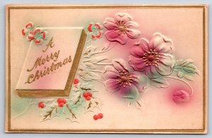 A Merry Christmas~Book W/ Flowers & Holly~Gold Border~Embossed~Vintage Postcard