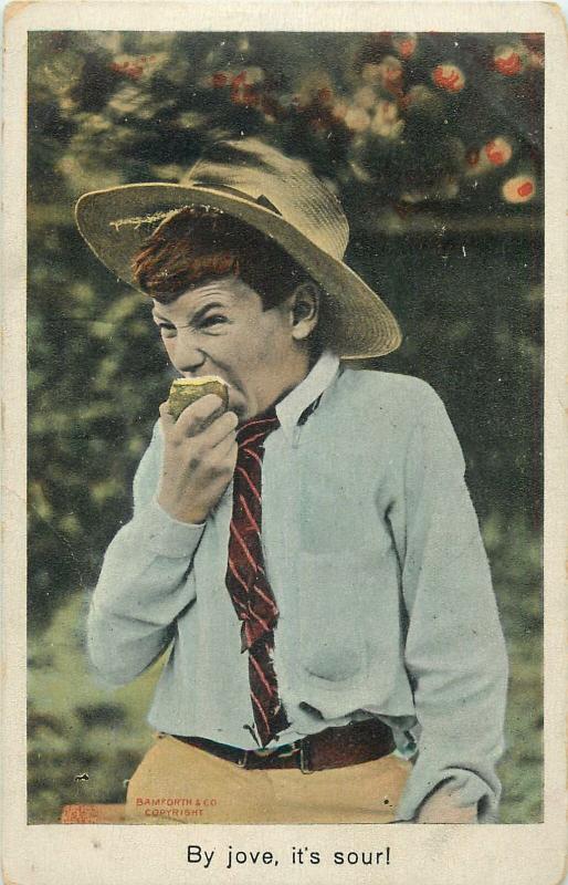 Bamforth humour postcard boy earing fruit comic face grimace By jove, it`s sour!