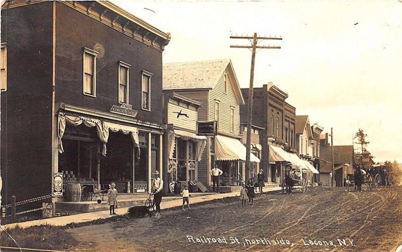 Lacona NY Railroad Street Baker Groceries Storefronts Dirt Street RPPC Postcard