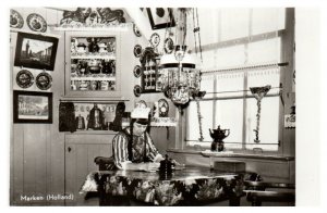 Person sitting at a table inside his cottage in Marken Holland RPPC Postcard