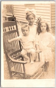 Siblings Photo Two Girls And A Baby On Wooden Chair Real Photo RPPC Postcard