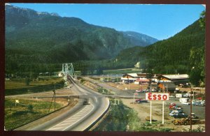 h2453- REVELSTOKE BC Postcard 1960s Rogers Pass Highway Bridge ESSO Gas Station