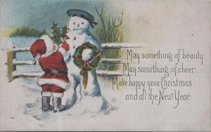 Postcard Little Boy Dressed in Santa Claus Outfit Building Snowman