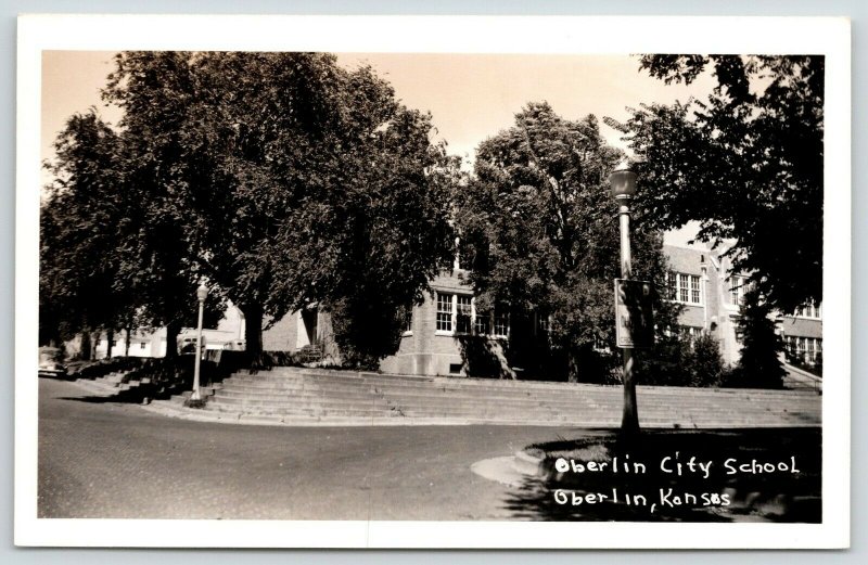 Oberlin KS~Curved Road Around City School~Terraced Stone Block Wall~RPPC c1950