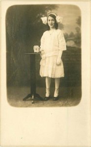 C-1910 Photo Studio girl wearing dress interior RPPC Photo Postcard 10494