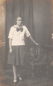 1910s RPPC Real Photo Postcard Girl Standing In Skirt With Dog On Chair