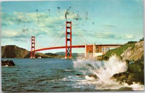 Golden Gate Bridge with waves crashing against rocks posted 1970