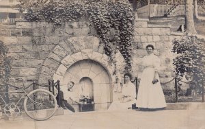 MAN & WOMEN GETTING WATER FROM SEA SERPENT WATER FOUNTAIN~REAL PHOTO POSTCARD