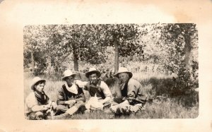 Postcard Four Men In Hats Resting Cigarette Grassy Field Sunny Real Photo RPPC