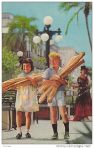 YBOR CITY, Florida; Children carrying long, crusty loaves of Cuban Bread, 40-60s