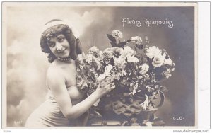 RP; Woman wearing straplass dress posing next to vased flowers, fleurs epanou...