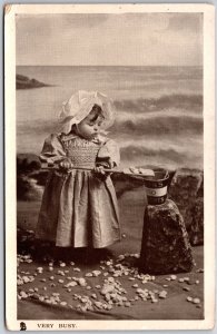 Very Busy Cute Little Girl Busy Playing Stones In The Ocean Postcard