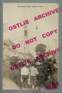 Lyons IOWA RPPC 1908 FIREMEN'S DAY Fireman CLIMBING LADDER Crowd nr Clinton IA