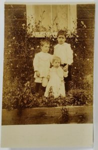 RPPC Standing the Children in the Flower Bed for a Picture c1900s Postcard R2