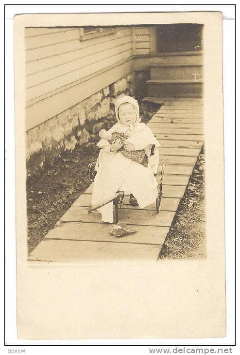 RP: Little girl holds doll sitting in a wagon in front of her house, 10-20s