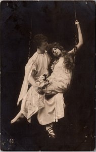 Real Photo Postcard Man and Woman Sitting on a Swing in a Photo Studio