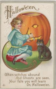 HALLOWEEN POST CARD OF GIRL IN BLUE, CARVING A LARGE PUMPKIN