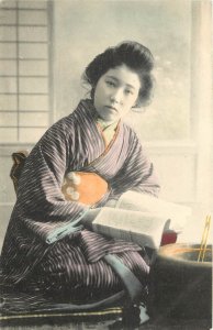 Hand-Colored Japanese Postcard; Beautiful Woman in Striped Kimono Reading a Book