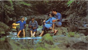 Family With Their Feet in the Water of a Stream Fishing 1980 