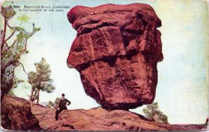 postcard CO - Balanced Rock, Garden of the Gods - Man in hat sitting near - 1920