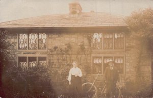 MAN & WOMAN WITH BICYCLE IN FRONT OF HOUSE~BRITISH REAL PHOTO POSTCARD 