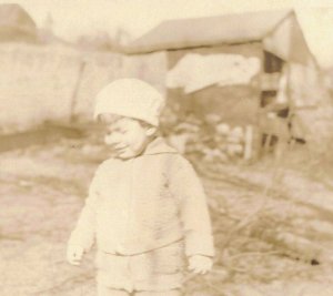 c.1901-07 Little Boy w/ Stocking Hat Wincing by Barn Real Photo 10C1-427 