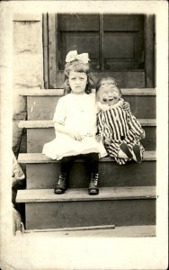 Little Girl Unhappy with Bizarre Creepy Doll Real Photo Vintage Postcard