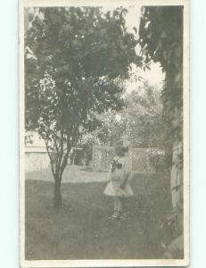 Pre-1917 rppc LITTLE GIRL WITH BOW IN HAIR UNDER TREE IN BACK YARD o2371