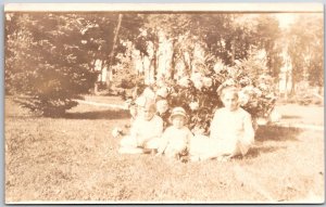 Children Sitting on Grounds Sunny Afternoon Flowers at Back RPPC  Postcard