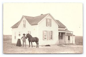 Postcard Old Farmhouse With Man Woman Horse Standing In Front RPPC