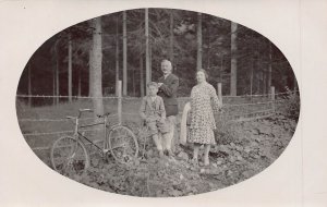 MAN WOMAN & SON WITH BICYCLE~1910s REAL PHOTO OVAL POSTCARD