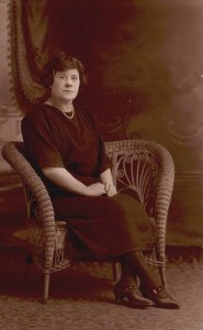 Woman in Black Dress Pearl Necklace Sitting on Wicker Chair Portrait RPPC PC