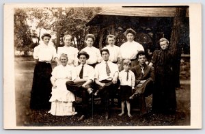 RPPC 7 Women~3 Men (1 In Dark-Color Suit)~Barefoot Boy~Cluster @ Rustic Shelter