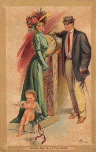 VALENTINE HOLIDAY CUPID LOVE ON THE WEIGH SCALE ROMANCE POSTCARD (c. 1910) PD