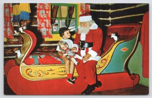 North Pole New York~Santa Claus @ Workshop on Sleigh with Child~1950s Postcard