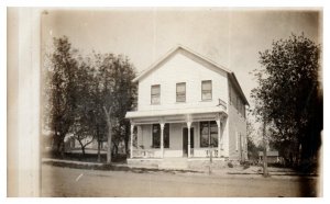 Old Home with large front porch built in between trees RPPC Postcard