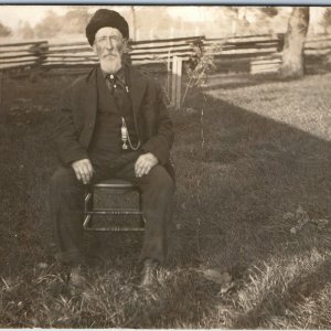 c1910s Handsome Older Man RPPC Outdoor Portrait Sitting Chair Stocking Cap A255