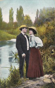 Romantic Couple Exchanging Smiles On River Bank