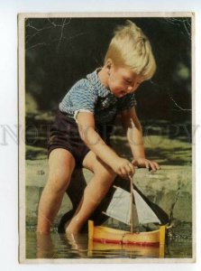 487629 Germany boy launching a sailboat Vintage postcard