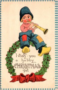 Christmas Postcard Dutch Boy Sitting on a Wreath Playing Musical Instrument