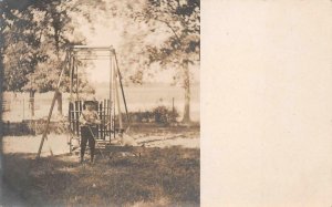 RPPC BOY IN PARK CAT IN ARMS DOG IN COASTER WAGON REAL PHOTO POSTCARD (c. 1910)