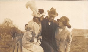 G64/ Interesting RPPC Postcard 1913 Man with Beautiful Women Hug Hats