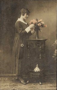 Pretty Woman Arranges Flowers TINTED REAL PHOTO c1910 Postcard