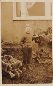 Young boy standing by a fountain Toy, Doll Writing on Back 