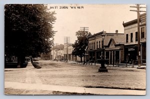 J90/ Juneau Wisconsin RPPC Postcard c1910 Oak Street Stores Fountain 424