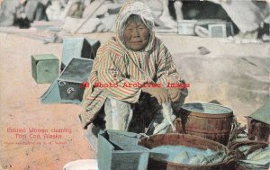 Native American Eskimo Woman Cleaning Tom Cod in Alaska, AYPE Logo