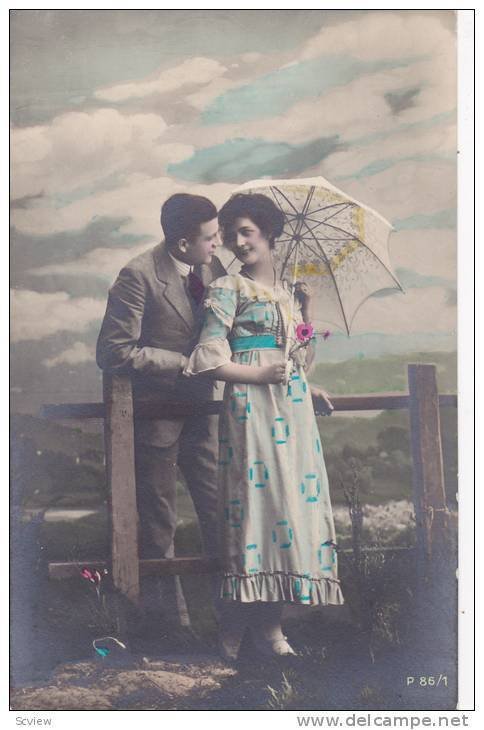 RP; Hand-tinted, Romantic couple, Man on one side of fence leaning toward lad...