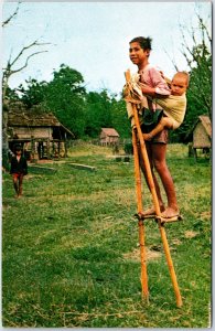 VINTAGE POSTCARD MONTAGNARD TRIBE BOYS ON BAMBOO STILTS AT KONTUM VIETNAM